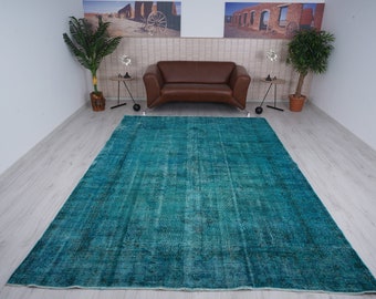 May include: A teal blue vintage rug with a distressed look. The rug has a faded, worn appearance, giving it a unique character.