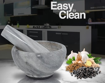 May include: A gray marble mortar and pestle set with the text "Easy to Clean". The mortar is round with a matching pestle. The image also shows garlic, ginger, and peppercorns.