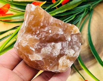 May include: A large, rough, orange and white agate crystal. The crystal has a translucent, cloudy appearance with a smooth, polished surface.