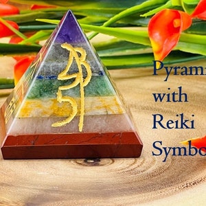 Pu&ograve; includere: Una piramide di cristallo a sette strati con simboli Reiki in oro. La piramide &egrave; realizzata in ametista, sodalite, aventurina verde, citrino, quarzo trasparente, quarzo rosa e diaspro rosso.