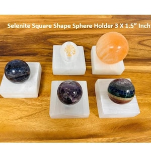 May include: Five selenite square shape sphere holders, each 3 x 1.5 inches, with various colored crystal spheres on top.