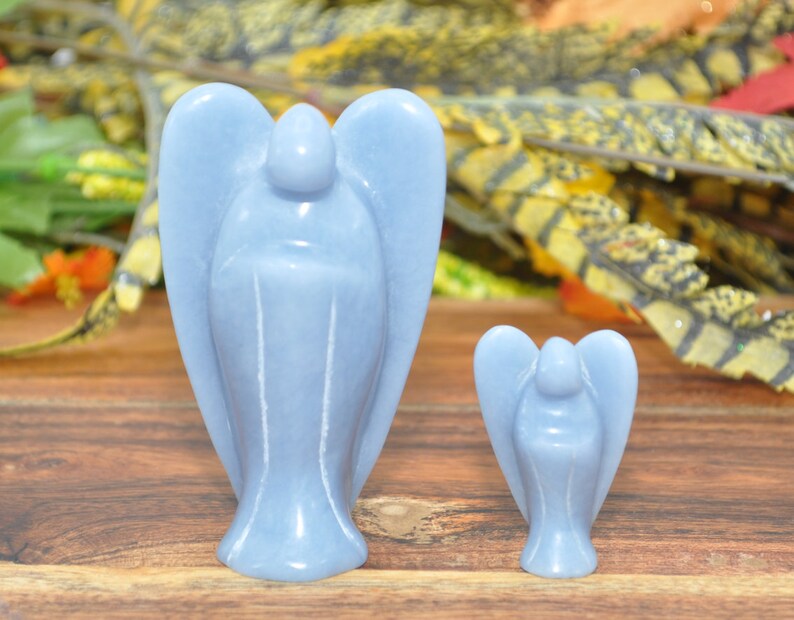May include: Two blue angel figurines carved from polished stone. The larger angel is about 4 inches tall and the smaller angel is about 2 inches tall.