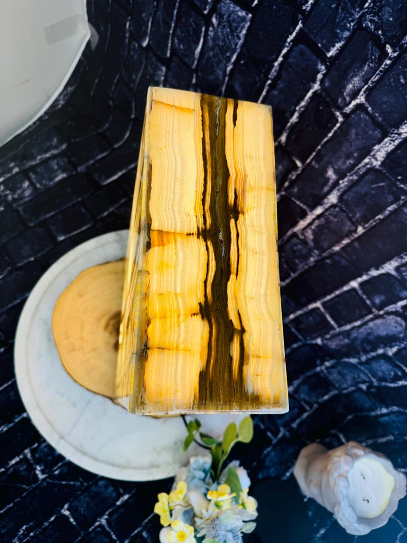 May include: A rectangular, yellow and brown onyx lamp base with a wood base. The lamp base has a natural, striated pattern.