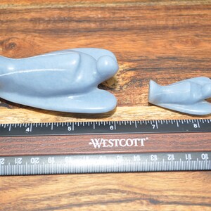 May include: Two blue angel figurines carved from stone. The larger angel is about 5 inches long and the smaller angel is about 3 inches long.