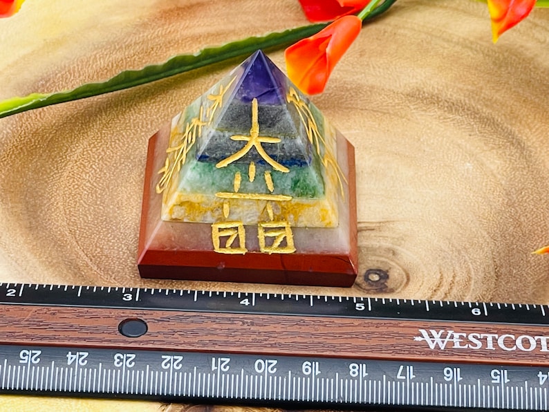 Pu&ograve; includere: Una piramide a sette chakra realizzata con diverse pietre, tra cui ametista, sodalite, aventurina verde, citrino, corniola, diaspro rosso e quarzo trasparente. La piramide &egrave; incisa con caratteri cinesi dorati.