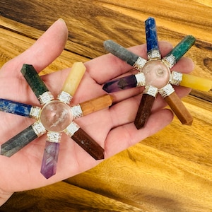 May include: Two chakra balancing crystal wands with a clear quartz crystal in the center. The wands are made of various crystals, including amethyst, lapis lazuli, clear quartz, and tiger's eye.