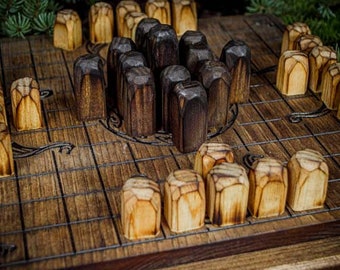 May include: A wooden game board with a grid pattern and a central circle. The board is filled with wooden pieces, some light brown and some dark brown. The pieces are arranged in a pattern, with the light brown pieces on the outside and the dark brown pieces in the center.