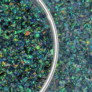 May include: A close-up image of iridescent green opal chips, some wet and some dry. The wet chips are in a clear glass bowl, while the dry chips are spread out on a surface. The text "Wet" is written below the bowl and "Dry" is written below the dry chips.