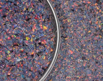 May include: A close-up image of iridescent opal chips, showing the difference in appearance when wet and dry. The left side shows the chips in a clear glass bowl filled with water, labeled "Wet". The right side shows the chips dry, labeled "Dry".
