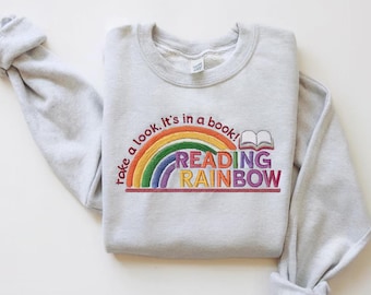 May include: A gray sweatshirt with a rainbow and the text "Take a look. It's in a book! Reading Rainbow" embroidered on the front.