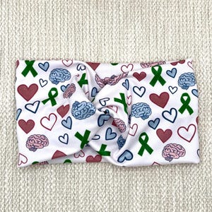 Wide, twisted headband with green ribbon, pink and blue brain, and pink and blue heart print.