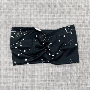 Wide, twisted headband in black with white galaxy theme print.