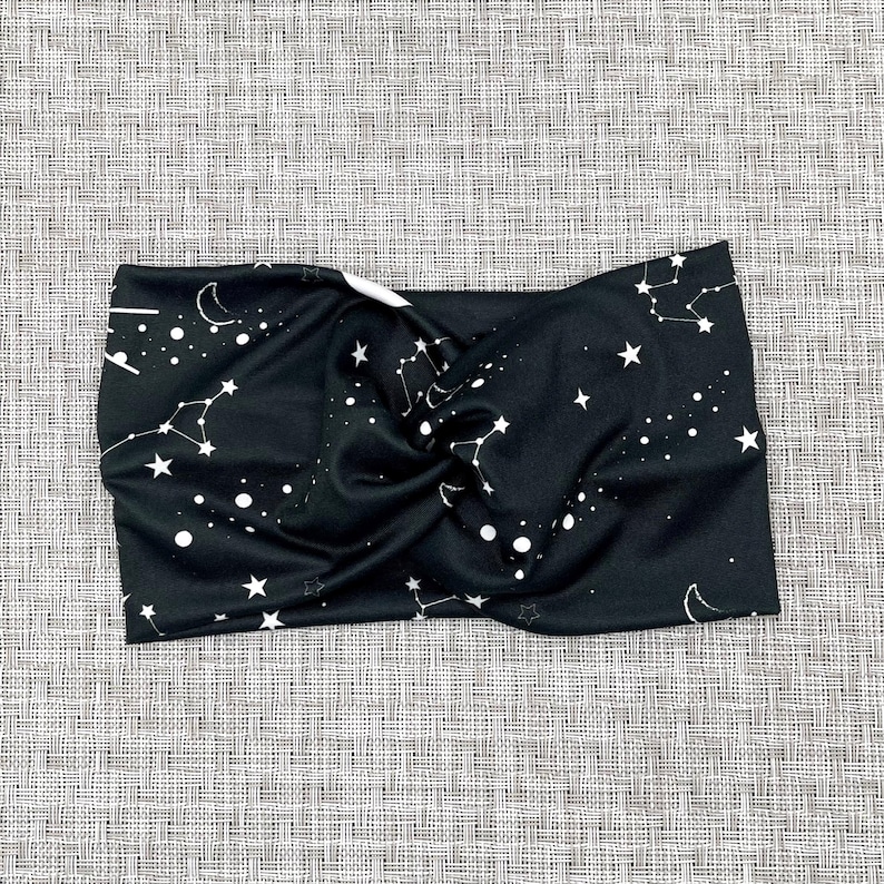 Wide, twisted headband in black with white galaxy theme print.