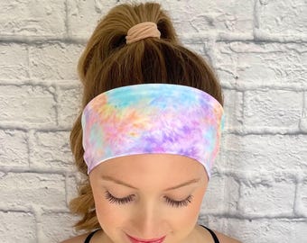 May include: A tie-dye headband in shades of purple, pink, blue, and yellow. The headband is made of a soft, stretchy fabric and is perfect for keeping hair out of your face.
