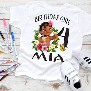 Pode incluir: Camiseta branca com um gr&aacute;fico colorido de um personagem de desenho animado, flores e borboletas. O texto "Birthday Girl 4 Mia" est&aacute; impresso na camiseta.