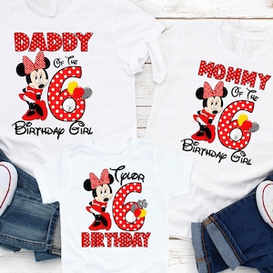 May include: Three white t-shirts featuring red and white polka dot Minnie Mouse designs. The shirts read "Daddy of the Birthday Girl", "Mommy of the Birthday Girl", and "6th Birthday".
