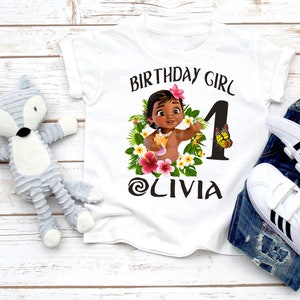 Pode incluir: Camiseta branca com um gr&aacute;fico de uma menina de desenho animado com flores e uma borboleta. O texto "Birthday Girl" e "Olivia" est&aacute; impresso na camiseta.