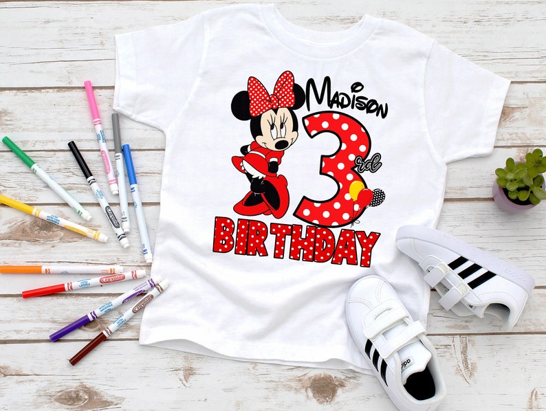 May include: White t-shirt featuring a red and white polka dot Minnie Mouse design. The shirt reads "Madison's 3rd Birthday".