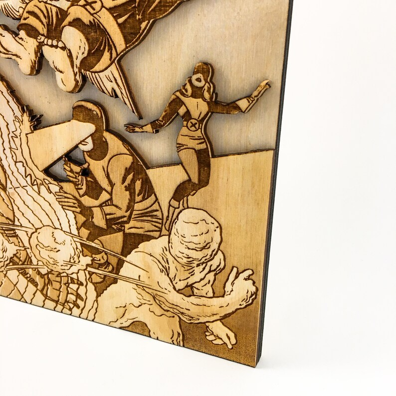 May include: A wooden wall art piece featuring a comic book style illustration of superheroes fighting a monster. The artwork is laser cut and has a brown wood finish.