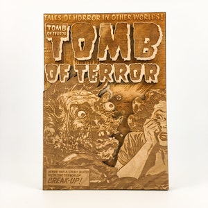 Może przedstawiać: Drewniany wycinany wzór vintage okładki komiksu zatytułowanej "Tomb of Terror" z potworem i kobietą w stanie strachu. Tekst na okładce brzmi "Tales of Horror in Other Worlds!" i "Never has a story burst with the terror of Break-Up!"