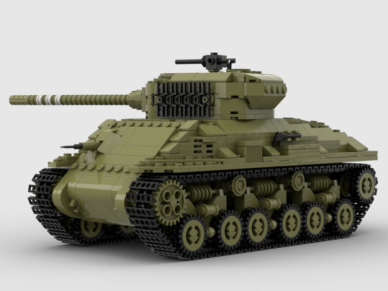 May include: A green toy tank with black tracks and a detailed design. The tank has a long barrel and a small turret on top.