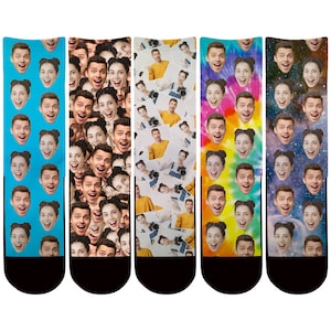May include: Six pairs of colorful socks with a repeating pattern of faces. The socks are all different colors and patterns, including blue, green, yellow, orange, and red. The faces are all different, but they all have the same basic features.