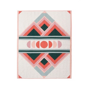 May include: A geometric quilt with a white background and a pattern of pink, red, and green triangles and squares. The center of the quilt features a row of red and pink circles.