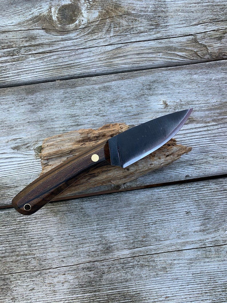 Full tang, 1084 high carbon steel, fiber liners, brass hardware and oil-finished zircote wood scales. Blade length of 3.5" and an overall length of ~8". Handmade right here in Maine.

This knife is made to order with a turnaround time of 1-2 weeks, if you would like to customize your order in any way please send us a message. Please be aware that customization may lengthen the time it takes me to make your knife.