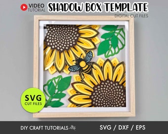 May include: A digital cut file template for a shadow box featuring two sunflowers with a bee in the center. The sunflowers are layered with brown, yellow, and gold paper. The bee is yellow and black. The template includes SVG, DXF, and EPS files.