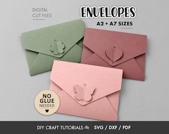 May include: Three paper envelopes in sage green, dusty rose, and light pink, each featuring a unique die-cut closure: a four-leaf clover, a heart, and a butterfly. Text reads: DIGITAL CUT FILES, ENVELOPES A2 + A7 SIZES, NO GLUE NEEDED, DIY CRAFT TUTORIALS, SVG / DXF / PDF.