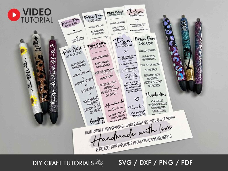 May include: A collection of handmade resin pens with glitter and decorative designs, including a sunflower, leopard print, and tropical scene. Accompanying care instruction cards and a "Handmade with love" card are also visible.