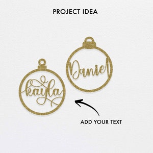 K&ouml;nnte beinhalten: Zwei goldene Glitzer-Weihnachtsbaumschmuck-Ausschnitte mit den Namen "Kayla" und "Daniel" in Kursivschrift. Ein Pfeil zeigt auf den Anh&auml;nger mit "Daniel" und der Text "ADD YOUR TEXT" befindet sich darunter.