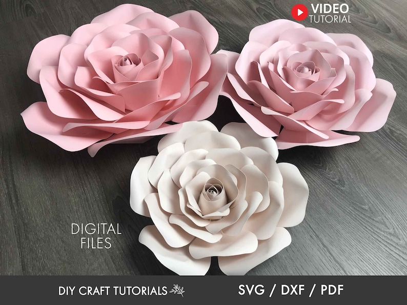 May include: Three large paper flowers, two pink and one white, with layered petals. The flowers are arranged on a woodgrain surface. The text "DIGITAL FILES" and "SVG / DXF / PDF" are visible at the bottom of the image.