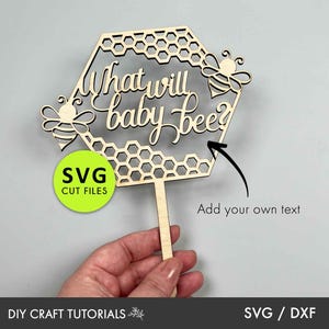 May include: Wooden cutout of a honeycomb with the text "What will baby bee?" and two bees. The cutout is on a stick and can be used as a cake topper.