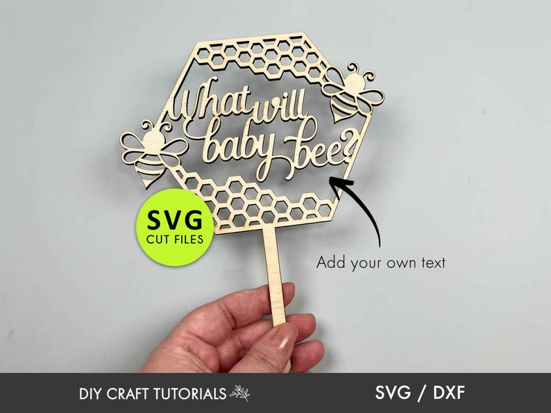 May include: Wooden cutout of a honeycomb with the text "What will baby bee?" and two bees. The cutout is on a stick and can be used as a cake topper.
