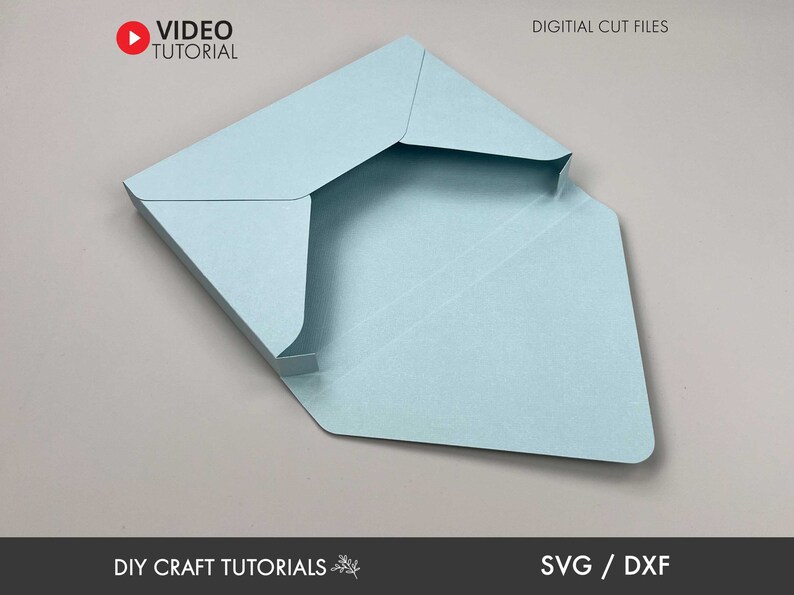 May include: A light blue paper envelope with a fold-over flap. The envelope is open and the inside is visible. The text "DIGITAL CUT FILES" is at the top of the image. The text "DIY CRAFT TUTORIALS" is at the bottom of the image. The text "SVG / DXF" is at the bottom right of the image.