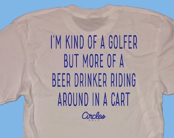 Op de afbeelding: Wit T-shirt met blauwe tekst die luidt: "Ik ben een soort golfer, maar meer een bierdrinker die rondrijdt in een karretje." De tekst staat in een blauwe cirkel met het woord "Circles" in witte tekst.