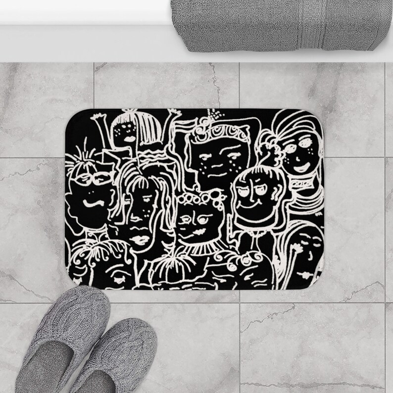 May include: Black and white bath mat with a graphic design of many faces. The faces are drawn in a cartoon style and are all different shapes and sizes.