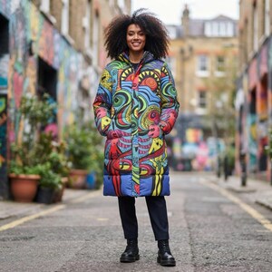May include: A knee-length puffer coat featuring a vibrant, multicolored graphic print with abstract shapes, swirling lines, and stylized figures in shades of blue, yellow, red, and green, paired with solid black trousers and black boots.