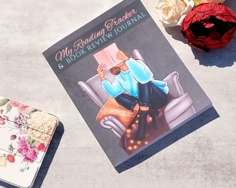 May include: A gray journal with the text "My Reading Tracker & Book Review Journal" on the cover. The cover features an illustration of a person sitting in a chair reading a book.