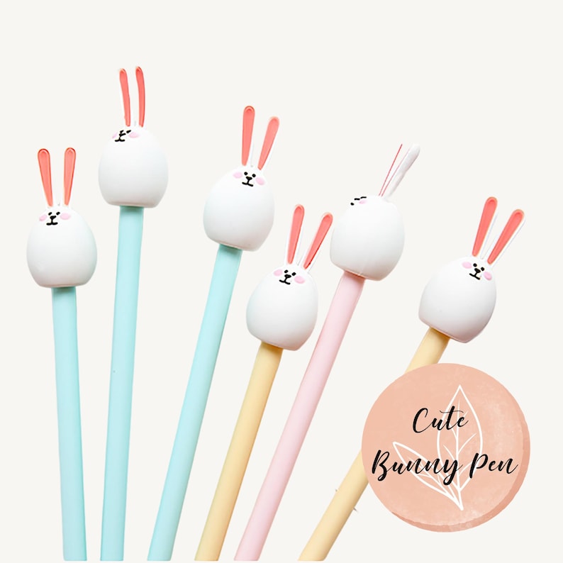 Puede incluir: Conjunto de seis bol&iacute;grafos de conejo lindo con cabezas de conejo blancas y orejas rosas. Los bol&iacute;grafos tienen ca&ntilde;ones de diferentes colores: azul, amarillo y rosa. El texto "Cute Bunny Pen" est&aacute; en un c&iacute;rculo de color melocot&oacute;n.