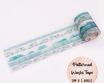 May include: Five rolls of patterned washi tape with a watercolor design of mountains, leaves, and flowers in shades of blue and green. The tape is 2 meters long per roll. The text on the label reads "Patterned Washi Tape 2M x 5 Rolls".