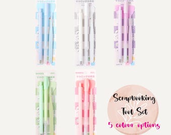 Puede incluir: Conjunto de cinco herramientas de scrapbooking, cada una de un color diferente: azul claro, blanco, morado claro, verde claro y rosa claro. Cada conjunto incluye un bolígrafo, una herramienta con una pequeña cuchilla y una herramienta con un pequeño cepillo. El embalaje está etiquetado en japonés.