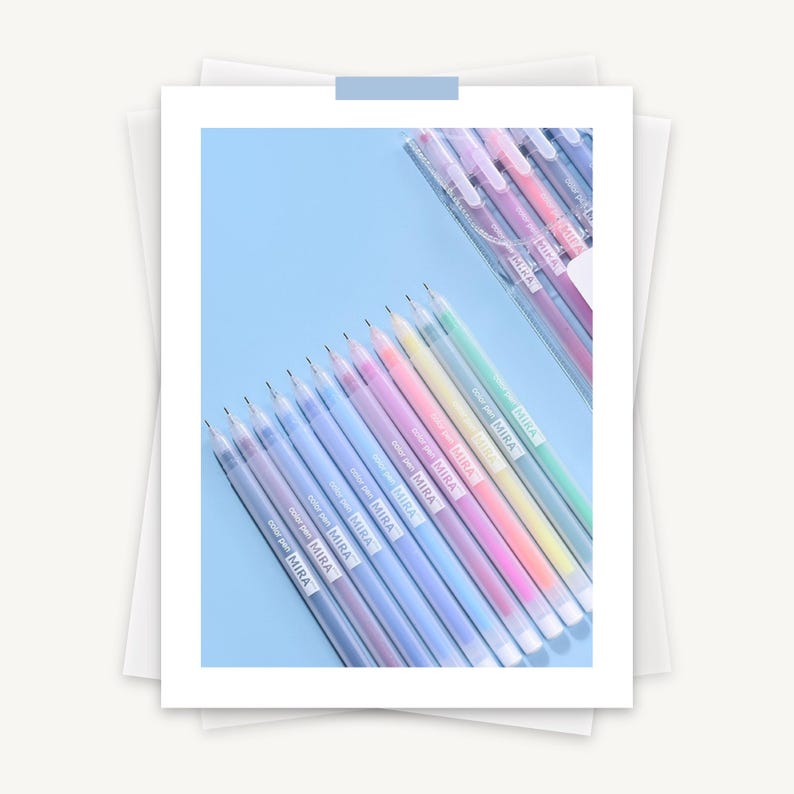 May include: A set of 12 pastel colored gel pens with clear barrels and silver caps. The pens are arranged in a row from darkest to lightest. The pens are labeled "MIRA" in black lettering.