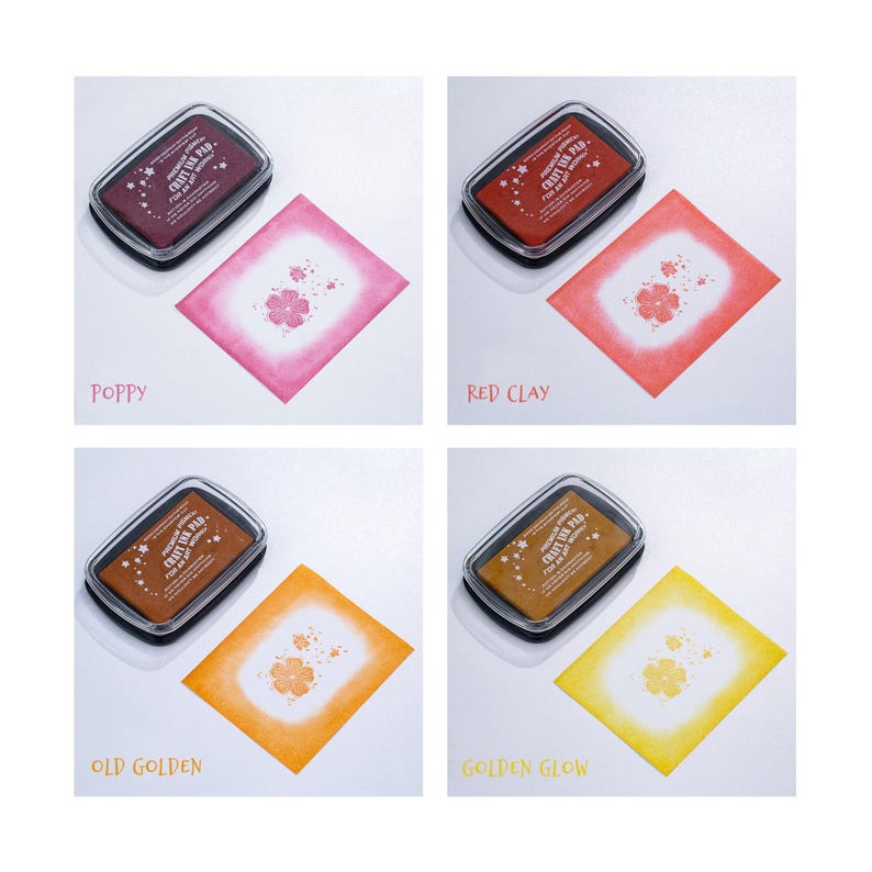 May include: Four ink pads in different colors: poppy, red clay, old golden, and golden glow. Each pad is labeled "Craft Ink Pad" and has a flower design. The ink pads are shown on a white background with a sample of each color ink on a white card.