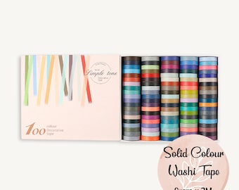 Puede incluir: Una caja de 100 cintas washi de color sólido en varios tonos. Las cintas tienen 8 mm de ancho y 2 metros de largo. La caja es rosa y tiene el texto "Simple tone Solid Decorative Tape".