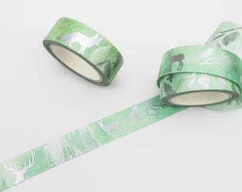 May include: Two rolls of green washi tape with silver foil accents. The tape features a woodland theme with images of deer, foxes, and birds.
