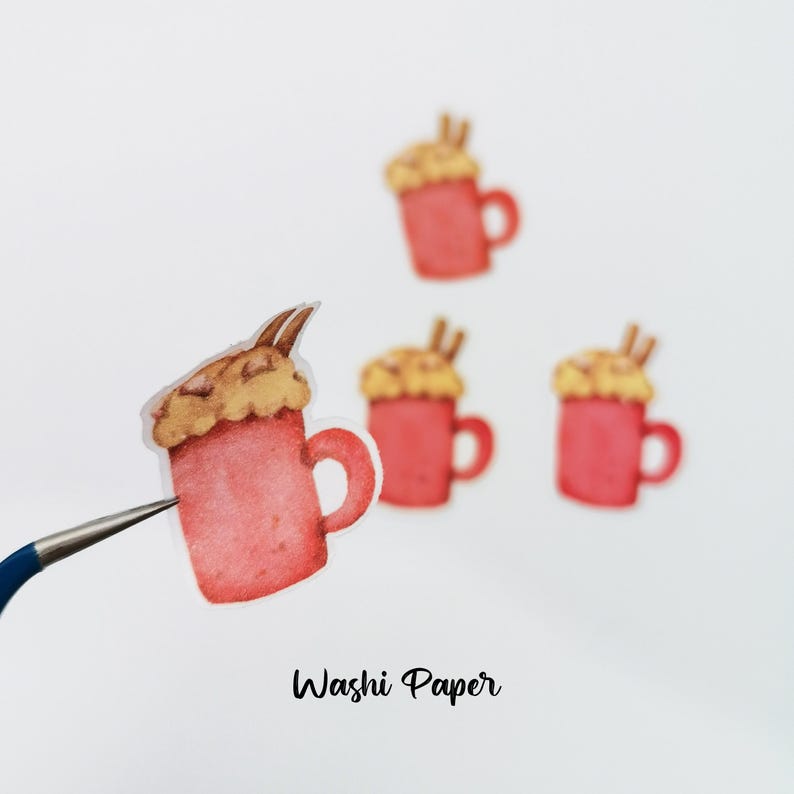 May include: Watercolor stickers of red mugs topped with whipped cream and cinnamon sticks. The stickers are in a watercolor style and are labeled "Washi Paper". The stickers are perfect for scrapbooking, journaling, or other crafts.