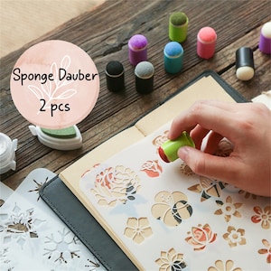 Może przedstawiać: Zestaw kolorowych gąbek do stemplowania na białym tle z tekstem "Sponge Dauber 2 pcs". Gąbki są używane do stemplowania i rękodzieła.