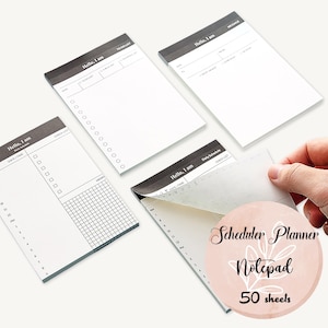 May include: A set of 50 blank notepad sheets with a black and white design. The notepad has the text "Hello, I am" and "Scheduler Planner Notepad" on the front.